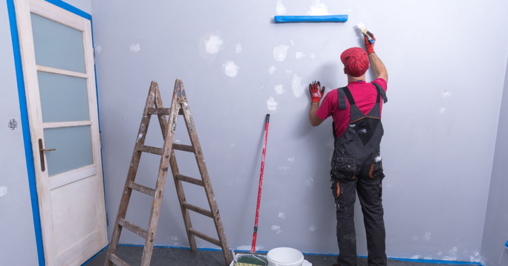 Image of a painter painting the inside of a business building.