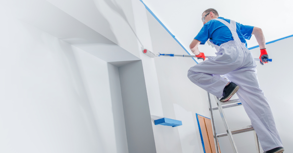 A painter from Cabinet Refinishing North Bay doing an expert job and applying a fresh coat of paint before adding airless spray to finish.